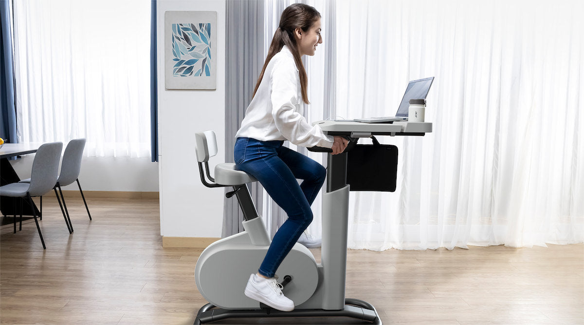 Acer eKinekt BD3 bike desk in use in an office, pedalling while working on a laptop